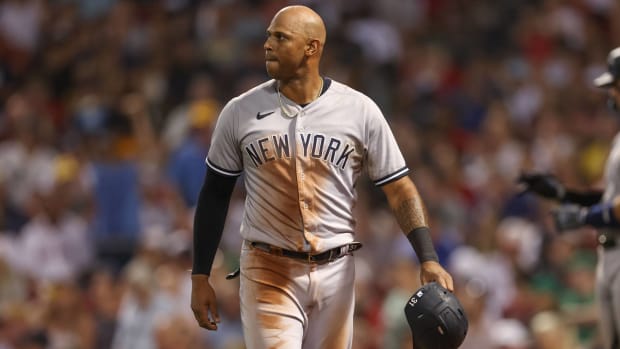 Yankees outfielder Aaron Hicks walks back to the dugout with his helmet in hand in between innings.